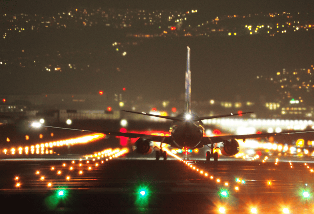 An aeroplane on a runway that is well-lit by comprehensive airfield lighting solutions.